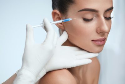 An image of a woman receiving a face injection